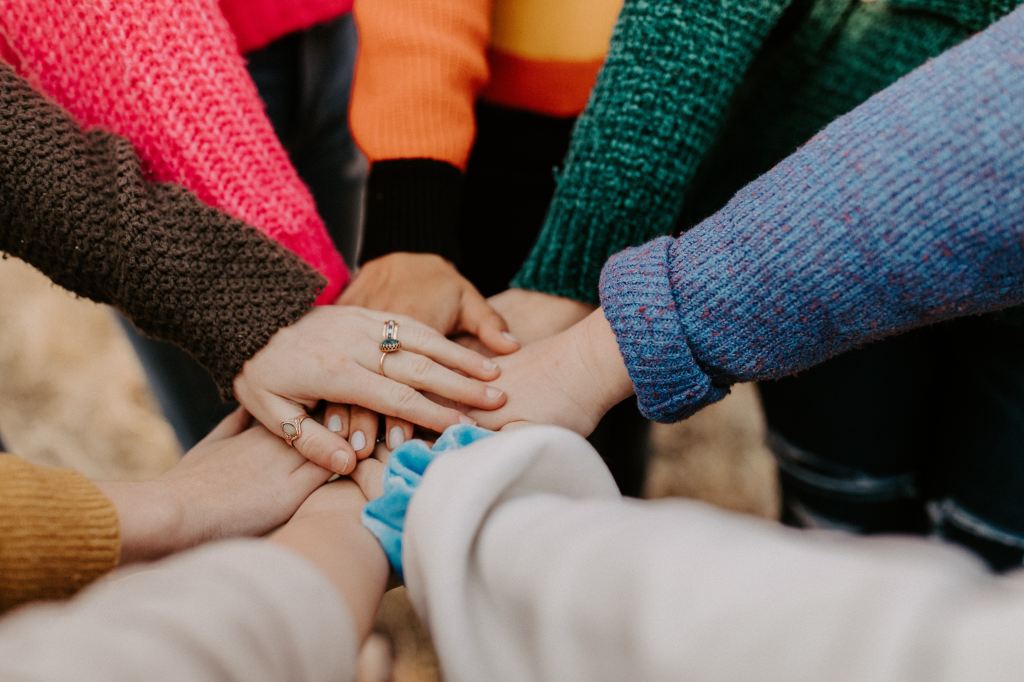 A group of people piling their hands together. 