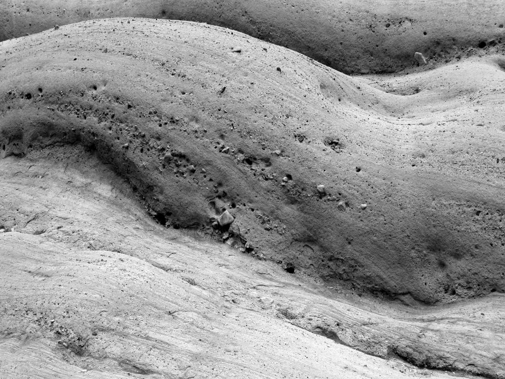A grayscale photo of wavy, textured rocks. 